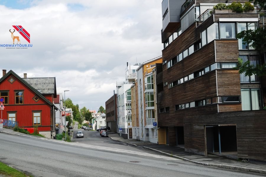 Road in Tromsø city with charming buildings and snow-covered landscape.