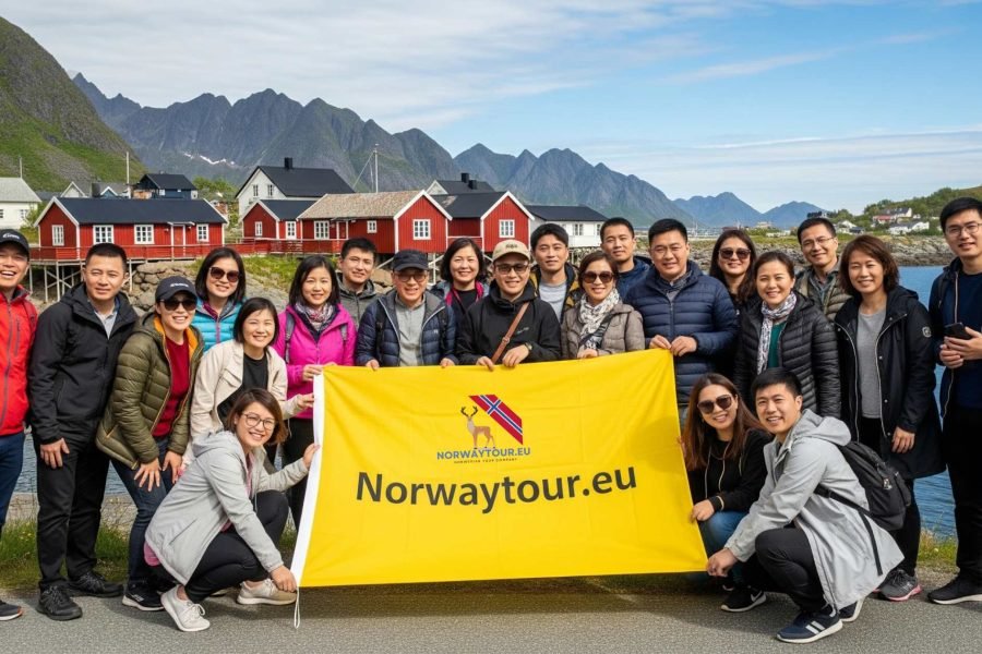 Group of tourists posing with Norwaytour.eu banner in front of red fishing cabins at Hamnøy during Lofoten Islands Photo Tour: Reine, Hamnøy & Skariskøya from Svolvær