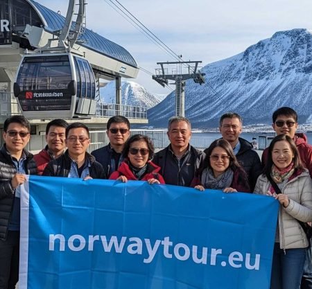 Travelers from Singapore at the base of Fjellheisen during their Tromso Cable car tour with norwaytour.eu